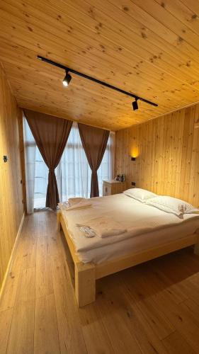 a bedroom with a large bed in a wooden room at Antari Project in Kapan