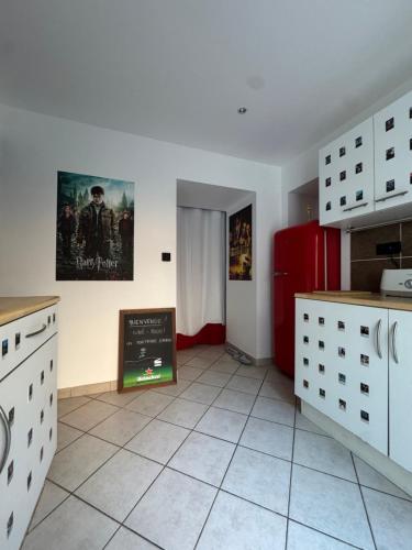 a kitchen with white cabinets and a sign on the wall at Cinéma Room - La Valette - Toulon - Hyères in La Valette-du-Var
