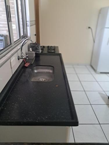 a kitchen counter with a sink in a room at Casa completa a 10 min do aeroporto Guarulhos in Guarulhos