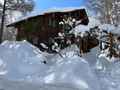 a pile of snow in front of a house at 蔵王ペンション kobaya in Kaminoyama