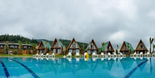 a row of cottages next to a large swimming pool at Bisanthe Panorama in Kumbağ