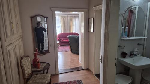 a man taking a picture of a bathroom with a mirror at Big & Bright City Center Apartment in Užice