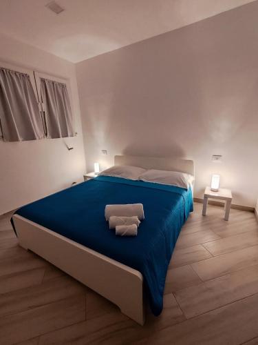 a bedroom with a blue bed with two towels on it at Alisea Home in Nerano