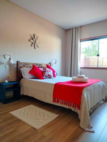 ein Schlafzimmer mit einem großen Bett mit roten Kissen in der Unterkunft Serra Santíssima - Casa completa perto do Centro in Tiradentes