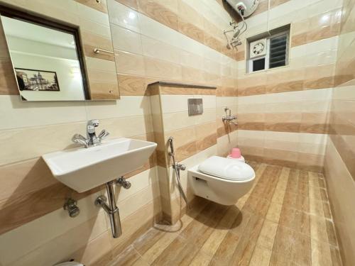 une salle de bain avec un lavabo et des toilettes dans l'établissement La Millionaire Resort, à Auroville
