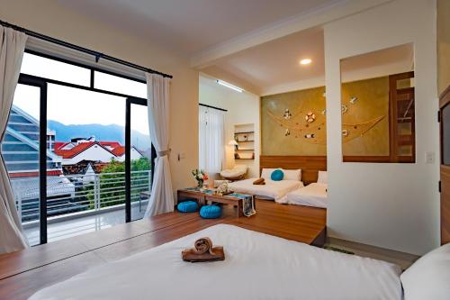 a bedroom with two beds and a large window at Villa De Doc Let Homestay in Nha Trang