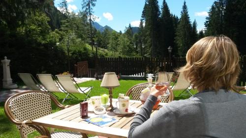 a woman sitting at a table with a glass of wine at Hotel Gianna in Madonna di Campiglio