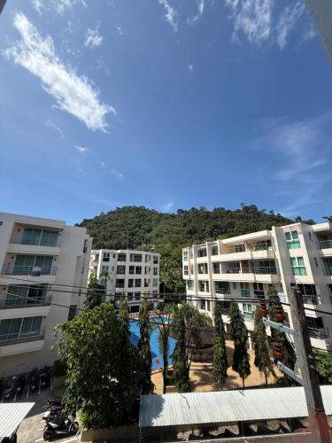 a view of apartment buildings with a mountain in the background at The Kris Residence in Patong Beach