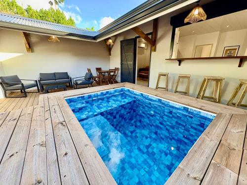 a swimming pool with blue water in a house at Villa O'CAMPÊCHE in Rivière-Salée