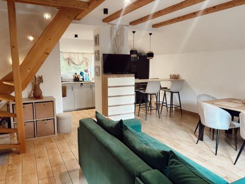 een woonkamer met een groene bank en een keuken bij Rzeczny Zakątek in Zawoja