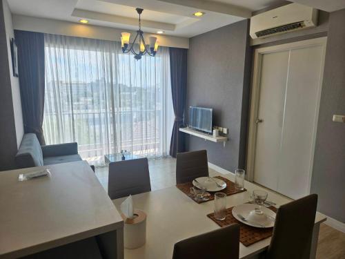 a living room with a table and chairs and a large window at The patio บางแสน in Ban Bang Saen (1)