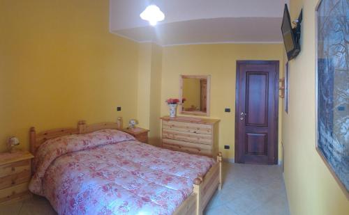 a bedroom with a bed and a dresser and a mirror at B&B Il Fratino in Pescocostanzo