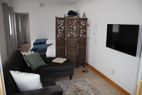 a living room with a couch and a tv at Cottage of Grace in Benoni