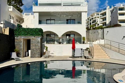 a swimming pool in front of a house at Malpique heated pool & Jacuzzi Guest House in Albufeira