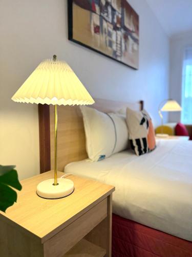 a bedroom with a bed and a table with a lamp at Beachcomber Motel & Apartments Apollo Bay in Apollo Bay