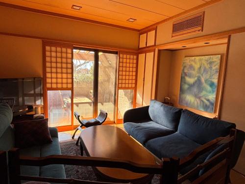 a living room with a couch and a table at 離れの宿 かぶろの庭 in Matsukawa
