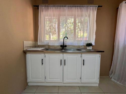 a kitchen with a sink and a window at Casa Bellé Bluff in Durban