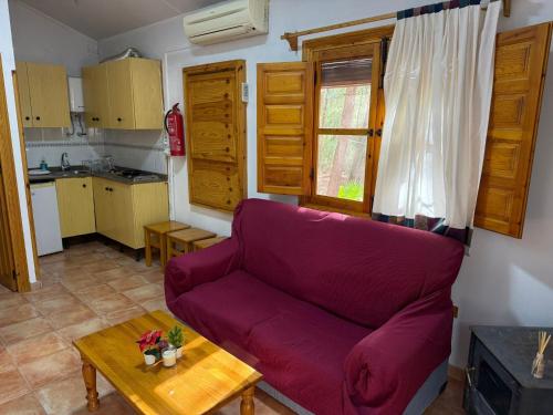 a living room with a purple couch and a table at Casas Rurales La Navela in Blanca
