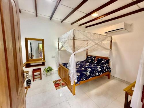 a bedroom with a canopy bed in a room at Thusitha s nest in Dickwella