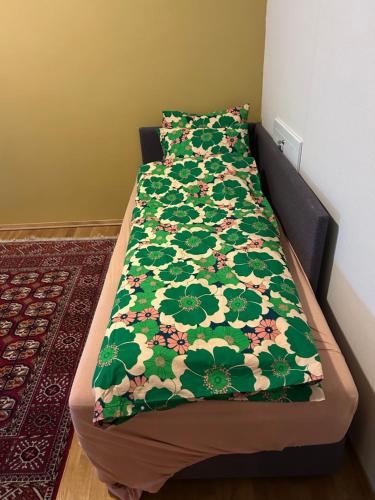 a bed with a green comforter on top of it at City home in Tromsø
