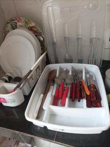 a white container filled with utensils on a kitchen counter at Suíte no cidade Jardim in Parauapebas