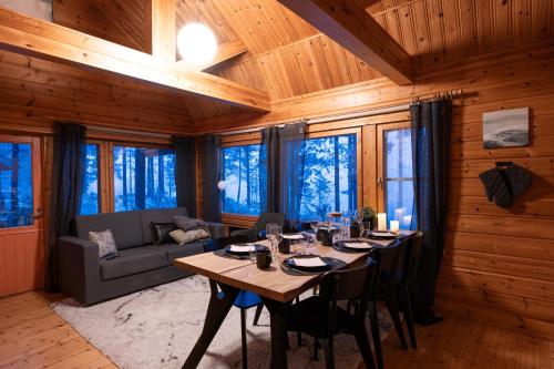 una sala da pranzo con un tavolo e un divano di Arctic Bear Resort - Lapland - Aurora suite - Sauna - Northern Lights a Ranua