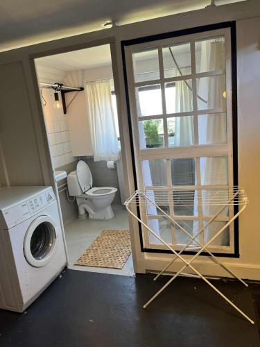 a bathroom with a washing machine and a toilet at Grandmothers home in Randers