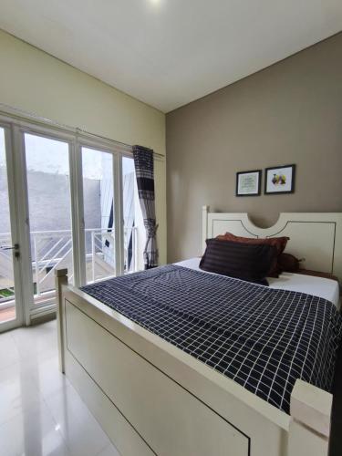 ein Schlafzimmer mit großem Bett und Balkon in der Unterkunft Villa Gamelas Kusuma Pinus Batu in Batu