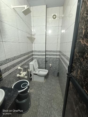 a bathroom with a toilet and a sink at Hotel Madhuram 450 Mtr Ringus Railway STN in Rīngas