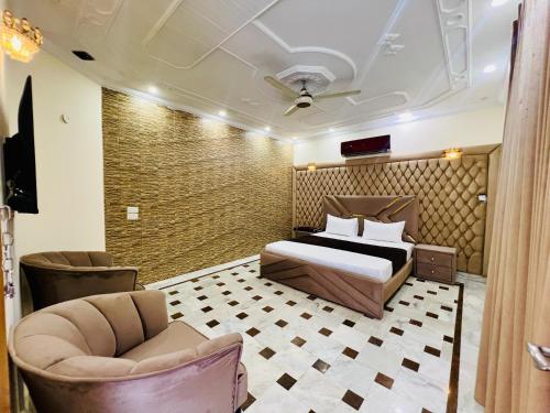 1 dormitorio con cama, sofá y sillas en Vista Lodge Guest House, en Islamabad