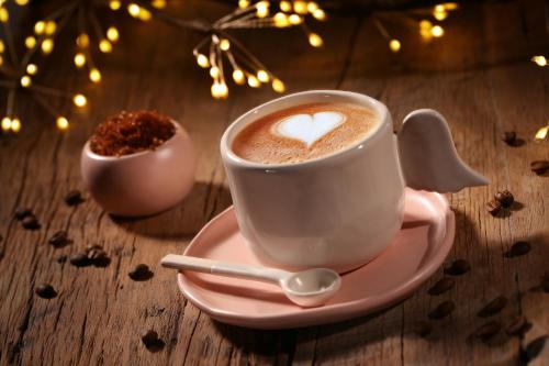 a cup of coffee on a plate on a table at Castelul de Lut - Eco Boutique Guesthouse in Porumbacu de Sus