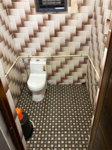 a small bathroom with a toilet in the middle at nandanam villlas in Guruvāyūr