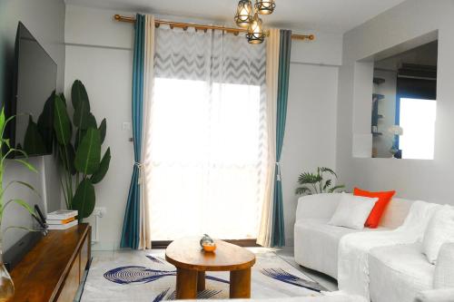 a living room with a white couch and a table at Myra Luxury Homes in Kololo- Your Family Oasis in Kampala