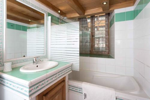ein Badezimmer mit einem Waschbecken, einer Badewanne und einem Spiegel in der Unterkunft Lou Lou Apartment - Chamonix All Year in Chamonix-Mont-Blanc