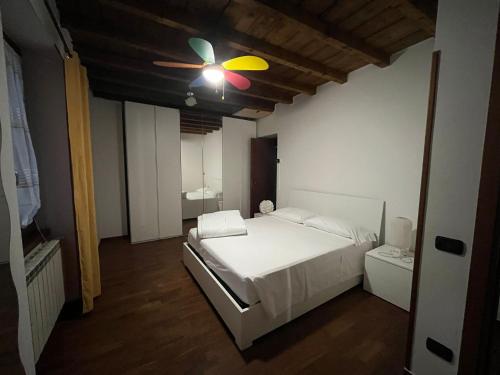 a bedroom with a white bed and a ceiling fan at IRIS - Spaziosa Casa Indipendente in Bergamo