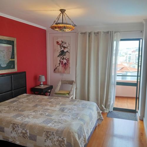 a bedroom with a bed and a red wall at Apartamento Silvestre Freitas in Funchal