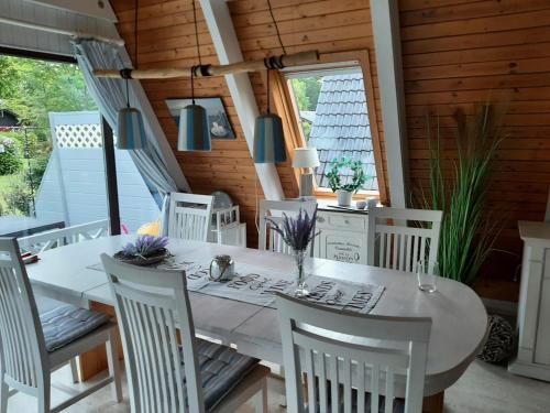 Un comedor con una mesa y sillas blancas. en Zum-Piraten, en Damp