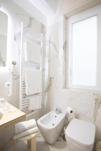 a white bathroom with a toilet and a sink at Primavera in Stresa