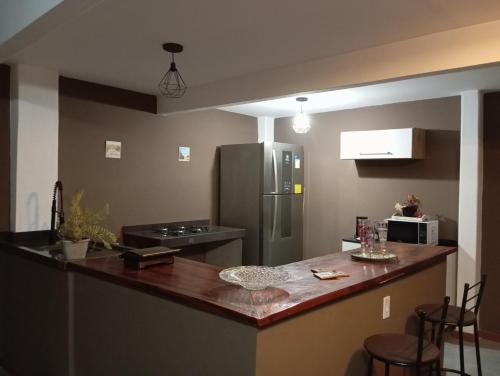 a kitchen with a counter top and a refrigerator at Aconchego Valença loft in Nova Friburgo