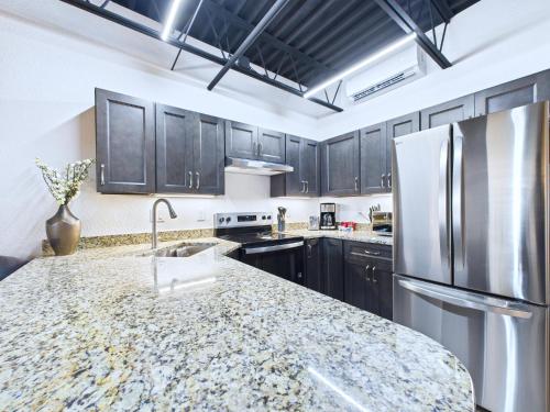 a kitchen with black cabinets and a granite counter top at Bright Modern Loft by Port & Beaches -Unit 206 in Cape Canaveral