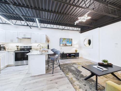 a kitchen and living room with white cabinets and a table at Modern Loft near Port, Beach, & Dining -Unit 201 in Cape Canaveral