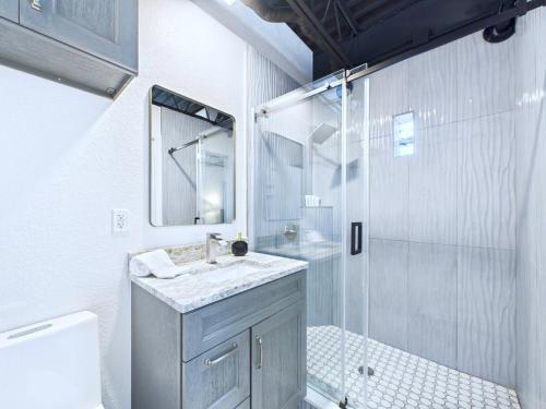 a white bathroom with a sink and a shower at Stylish Loft Minutes From Beach & Port - Unit 204 in Cape Canaveral