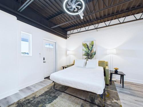 une chambre blanche avec un lit et une table dans l'établissement Sleek Coastal Loft Close To Port & Beach -unit 205, à Cap Carnaveral