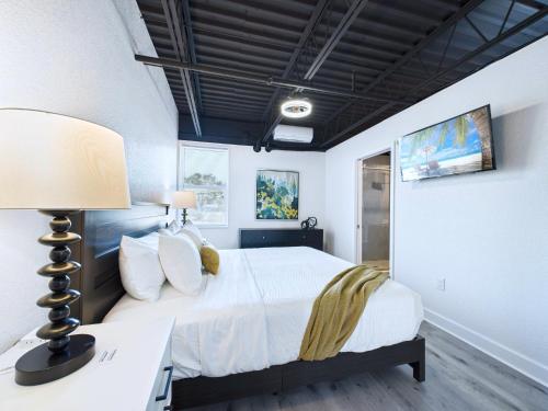 a bedroom with a bed and a desk with a lamp at Minutes to Port! Loft Near Dining & Fun -Unit 207 in Cape Canaveral