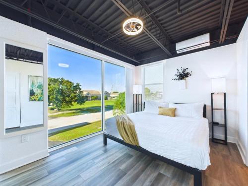 a bedroom with a bed and a large window at Rocket Launch View Loft Near Beach & Port-Unit 209 in Cape Canaveral