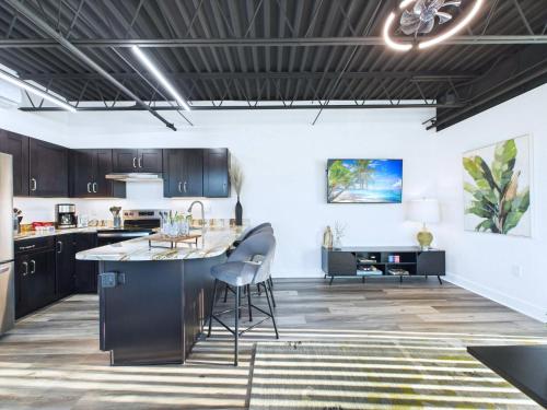 a kitchen with dark cabinets and a large island in a room at Rocket Launch View Loft Near Beach & Port-Unit 209 in Cape Canaveral