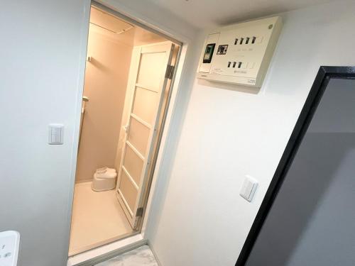 a small bathroom with a mirror and a toilet at Yokosuka Royal Bari House 703 in yokosuka chuo station in Yokosuka