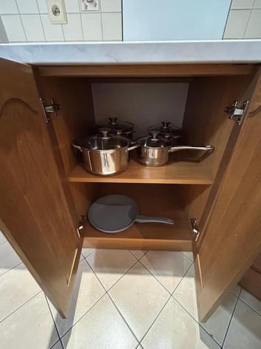two pots and pans on a shelf in a kitchen at Apartament na wyłączność - Tarnowskie Góry - Strzybnica in Tarnowskie Góry