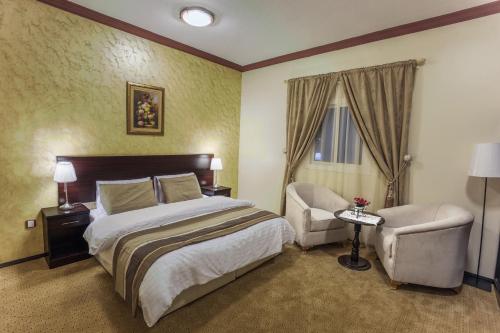 a hotel room with a bed and a chair at Manazel Al Sofara in Yanbu