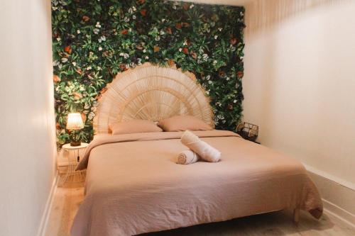 a bedroom with a bed with a flower wall at Appartement Jungle Cosy - Bureau & Fibre - Proche Futuroscope in Jaunay-Marigny